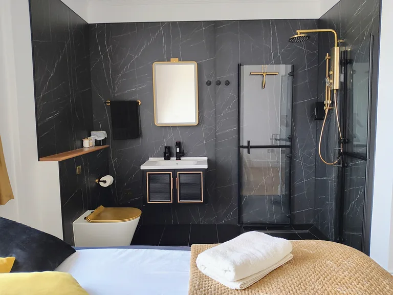 Ciel dOr suite luxury ensuite bathroom with dark marble and gold fixtures at Lavish Collections Great Yarmouth